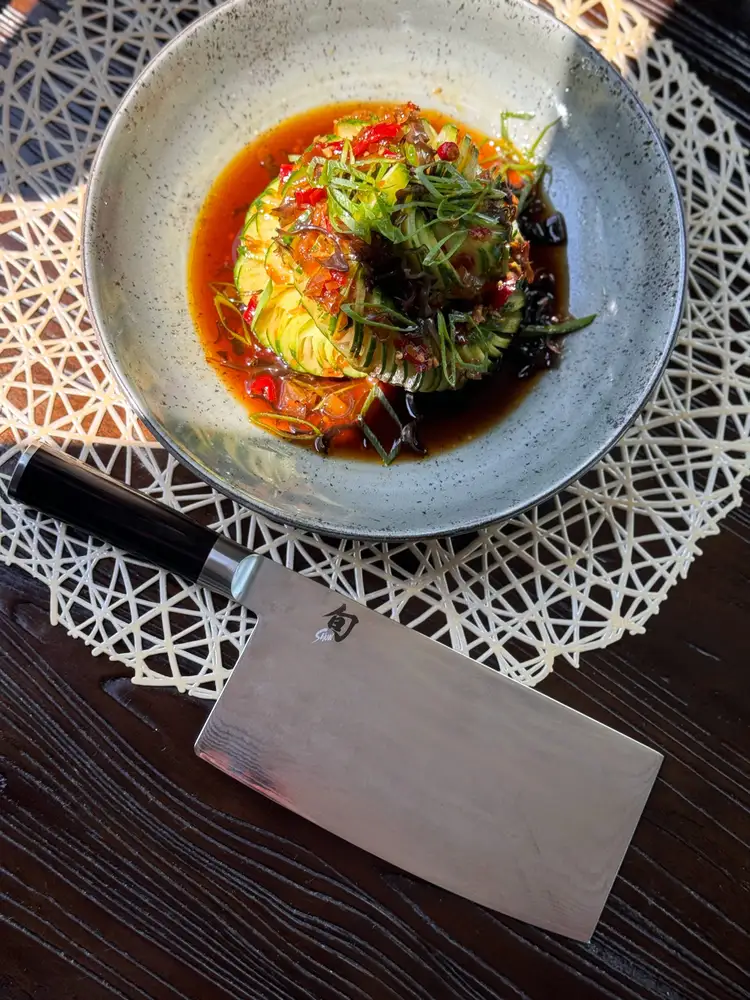 A close up of one of Chef Fang's dishes, next to a Classic Vegetable Cleaver.