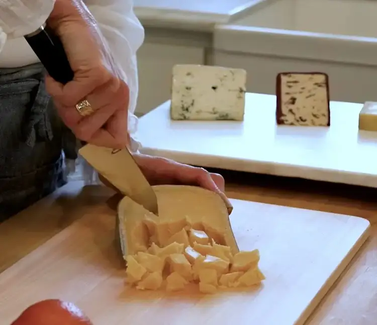 Breaking aged Gouda into craggy chunks using the tip of a Shun Classic Asian Multi-Prep knife.