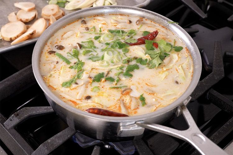 Coconut chicken soup in a pot on stove top