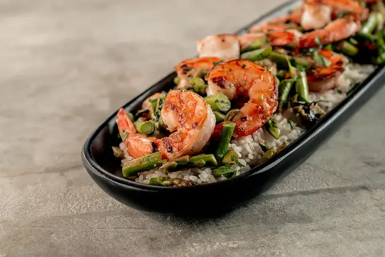 Garlic Shrimp with Asparagus plated on an oval ceramic stoneware plate.