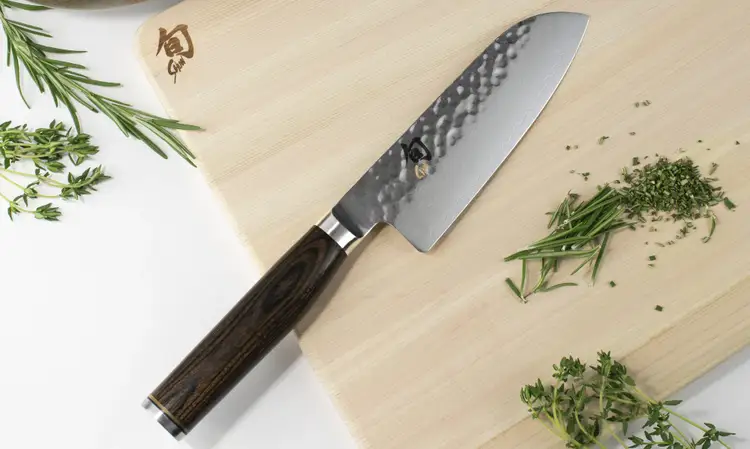 Shun Premier Santoku knife resting on a hinoki cutting board: Click to shop the Premier Santoku.