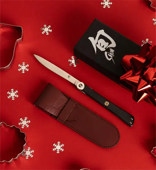 A personal steak knife lies next to its case.