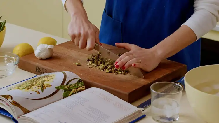 Molly Baz chops pistachios for her vinaigrette.