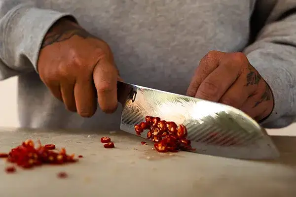 Chef Ni Nguyen dices pomegranate seeds with a Dual Core Santoku.