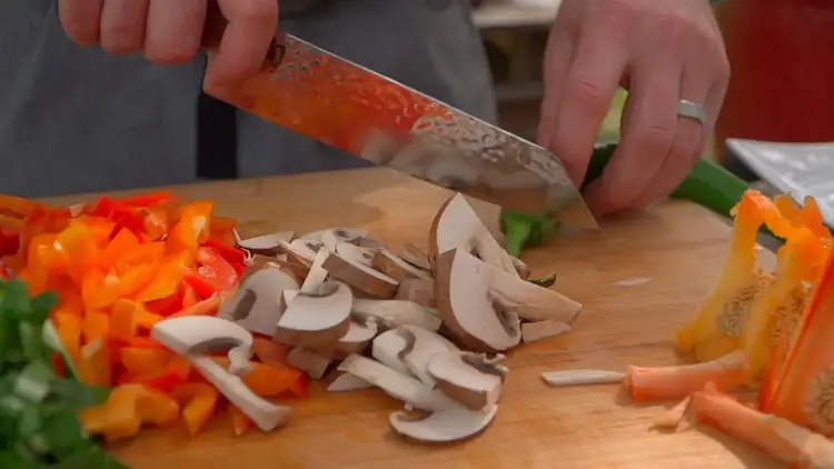 Eric Gephart slices vegetables for the salmon dish.