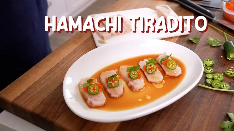 Hamachi sashimi in sauce with sliced peppers on top on a plate