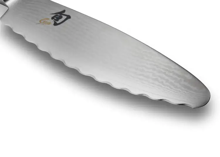 Close-up of the Ultimate Utility Knife’s low-frequency serrated edge with Shun logo visible.
