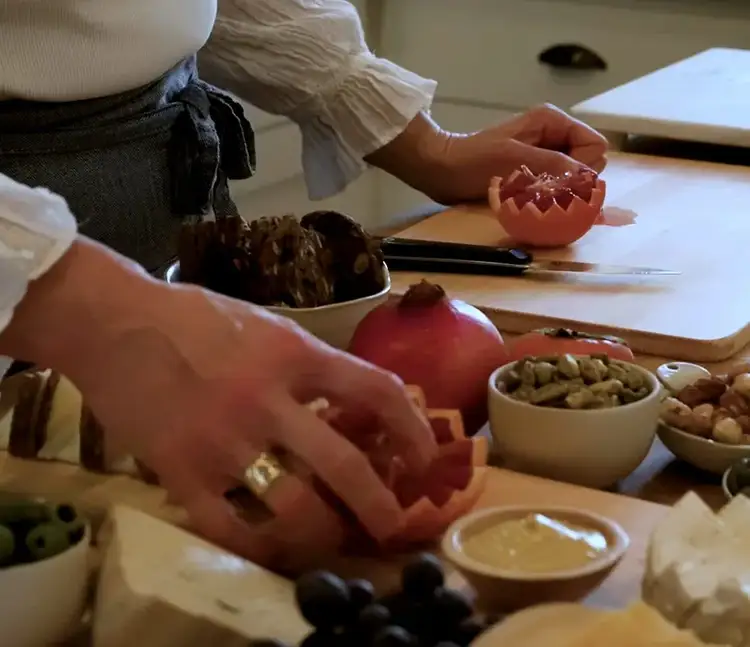 Placing a zigzag-cut blood orange half on the cheeseboard as a festive garnish.