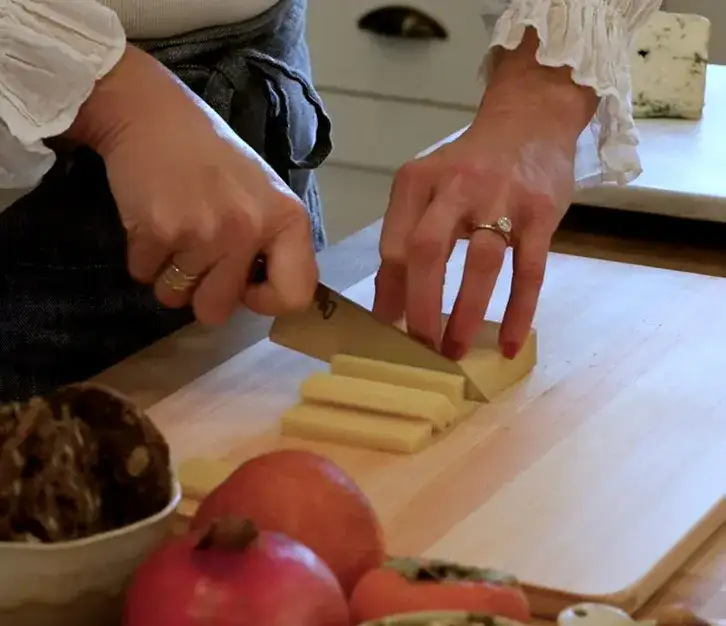 Slicing Alpine-style cheese with a Shun knife into even rectangular pieces.