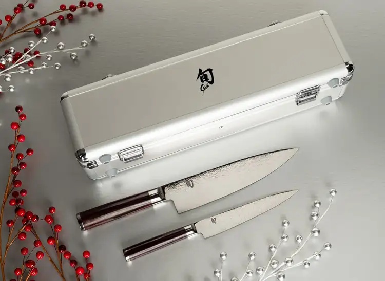 The Kohen Knife set is propped on a table in front of its carrying case.