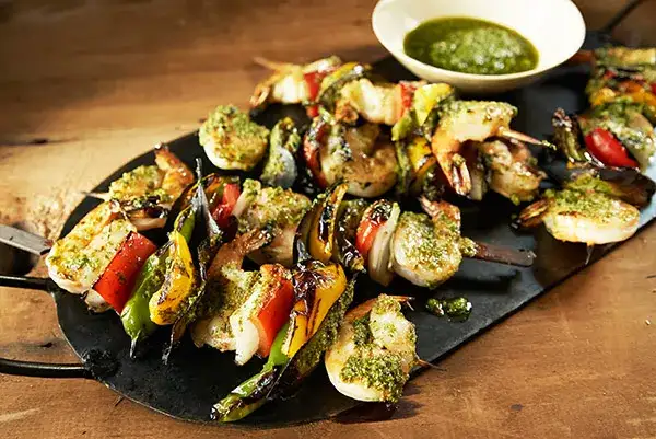 Mediterranean shrimp kebabs plated on a slate serving tray.