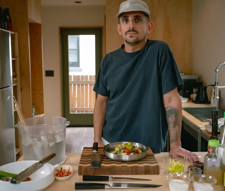 Chef Vince Morelli stands in his kitchen, Shun Dual Core knives in the forefront of the image.