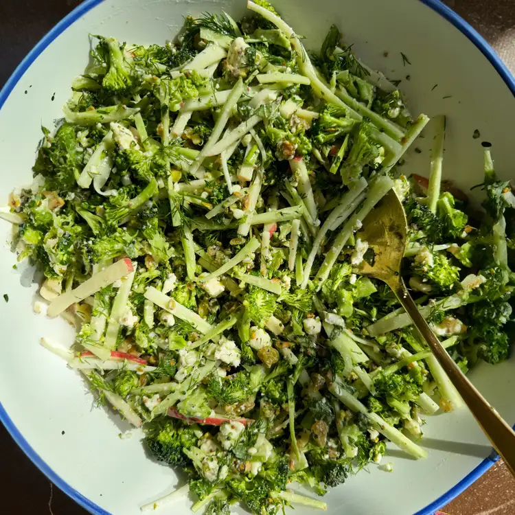 A delicous-looking serving of broccoli slaw on a blue-rimmed plate.