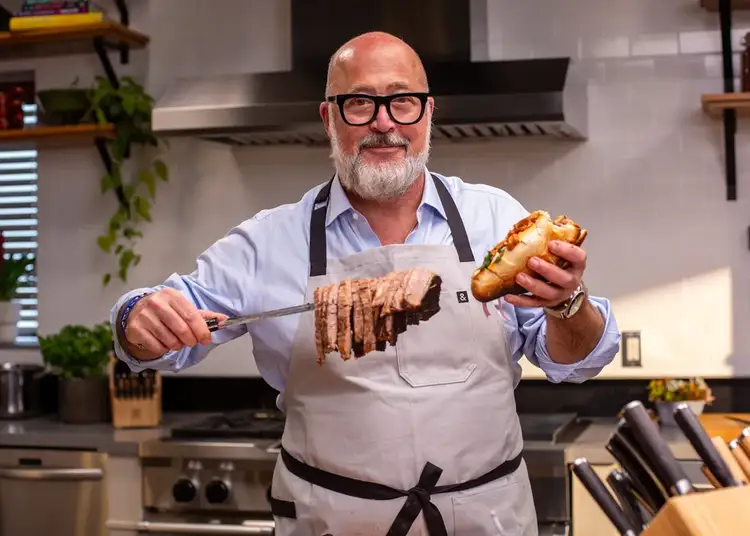Chef Zimmern lifts up sliced brisket on a brisket knife.