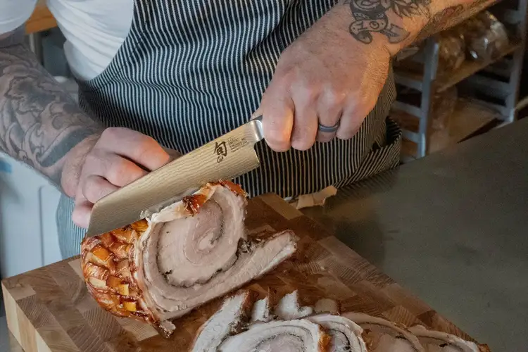 Chef Avery Hardin slices porchetta with a Shun Classic Master Utility Knife.