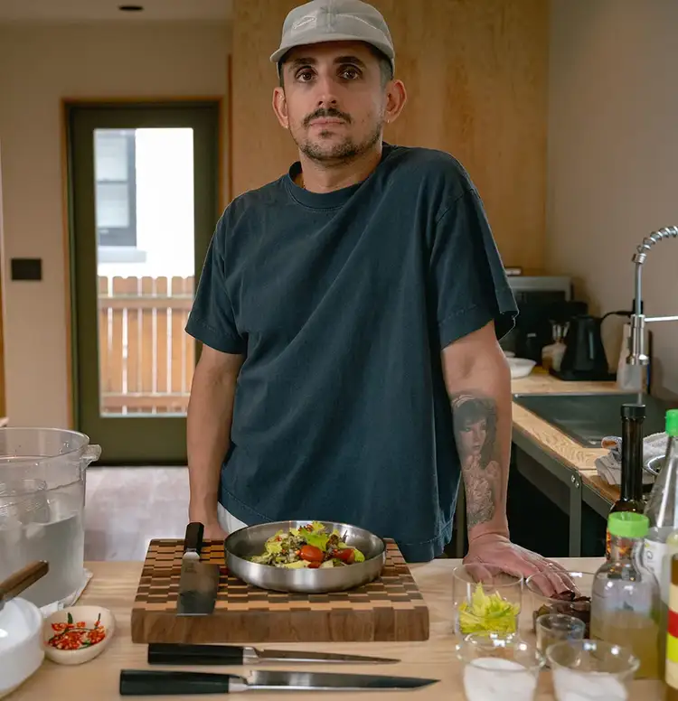 Chef Vince Morelli stands in his kitchen, presenting his squid salad. Click to read his interview.